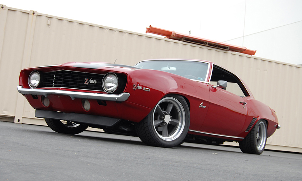 1969 Camaro featuring SPORT-R deluxe style seating with black vinyl, black suede, black and white hounds-tooth stooth cloth, and red contrast stitching. Includes matching rear seat and center console with SPORT-R door panels. 