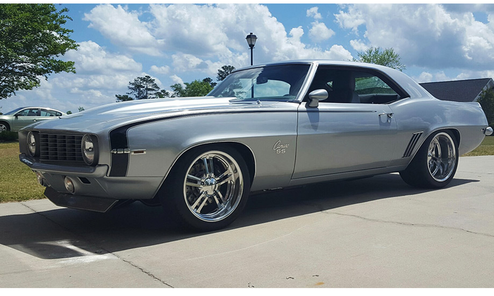 1969 Camaro featuring Universal Pro Series Low Back seats with SPORT-R500 design with no stripes, gray vinyl, black suede,  and black contrast stitching. Includes matching rear seat and center console with SPORT-R door panels. 