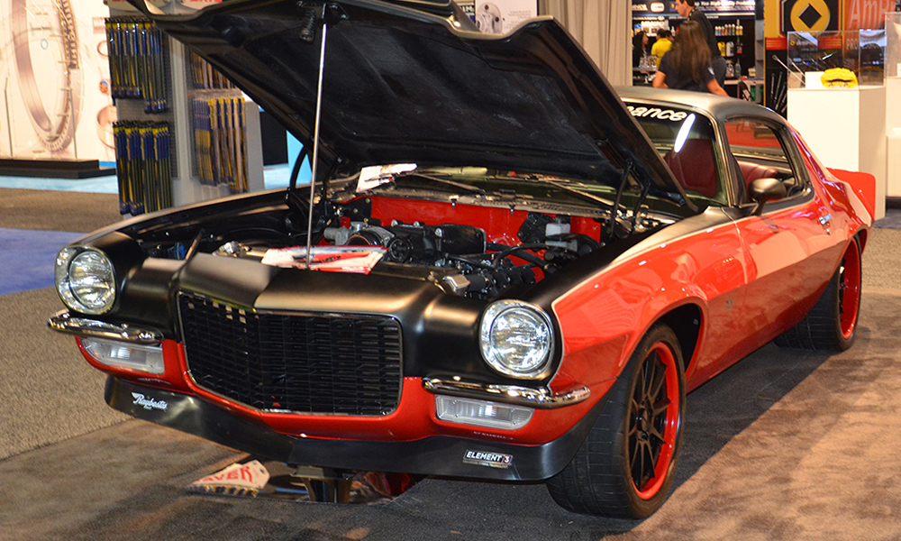 1971 Camaro featuring Universal Pro Series High Back seats with SPORT-XR design with red and black perforated vinyl, black suede, red contrast stitching, and black grommets. Includes matching rear seat, center console, door panels, and steering wheel.