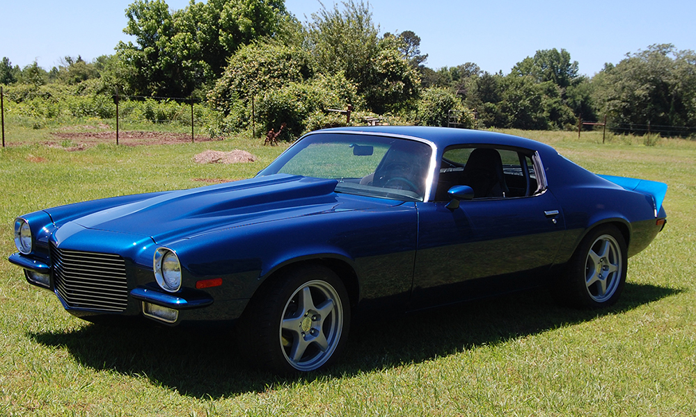 1973 Camaro featuring Universal Pro Series Villain seats with SPORT-XR design with black vinyl, gray suede, black contrast stitching, and black grommets. Includes matching rear seat, center console, and SPORT-R door panels.