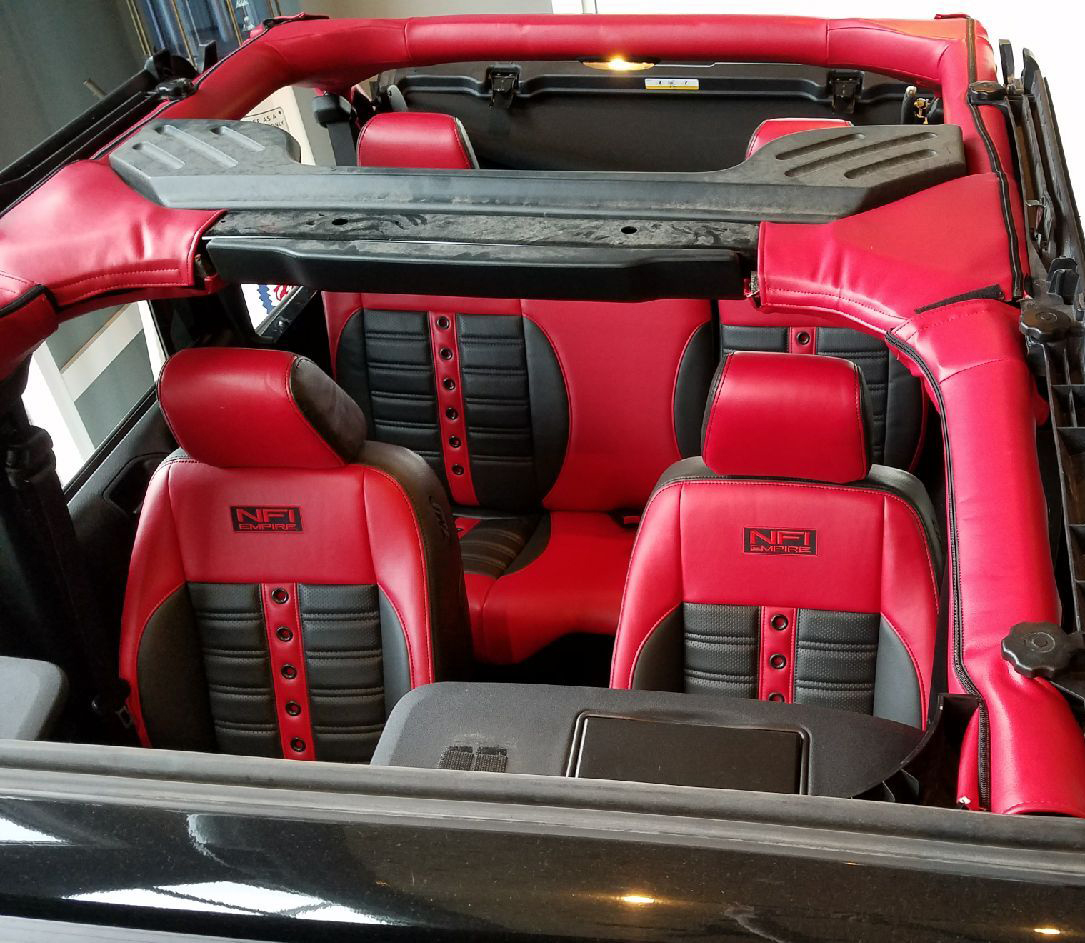 Jeep featuring Universal Pro Series Low Back seats in SPORT-XR design with red vinyl, black perforated vinyl accents, black contrast stitching, and black grommets. Includes matching rear seat.