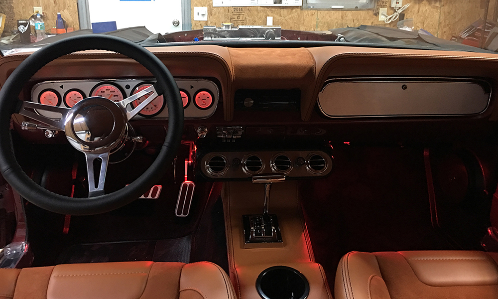 1965 Mustang featuring deluxe SPORT-R Pony seating with tan vinyl and suede. Includes matching dash pad, center console, door panels, rear seat, and trunk kit.