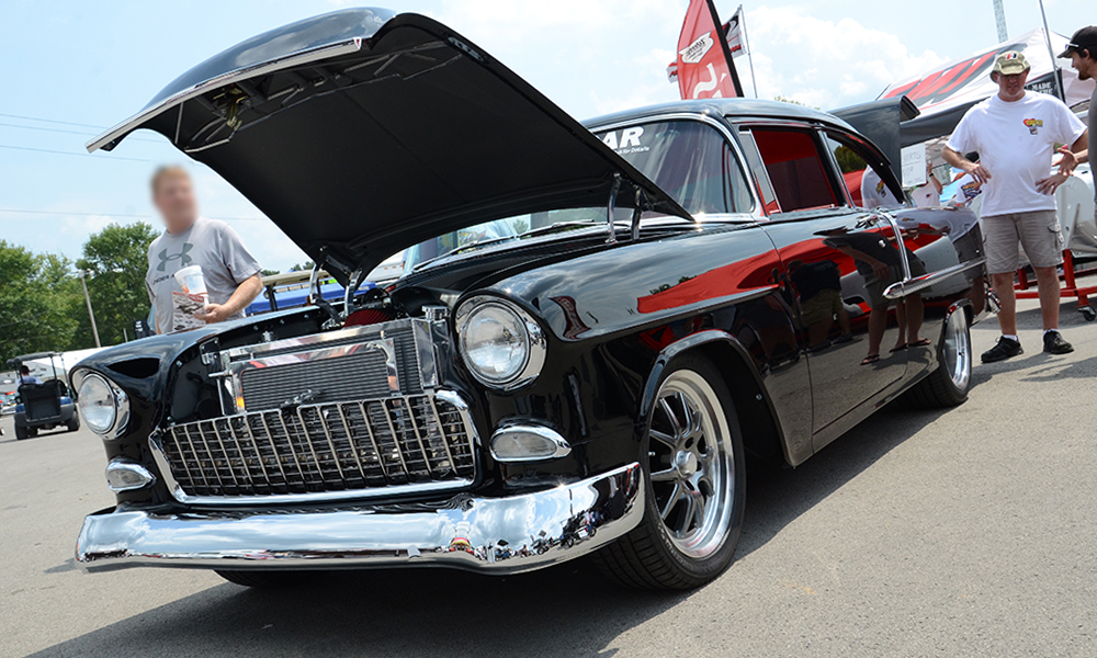 1955 Sedan featuring Universal Pro Series Low Back seat in SPORT-AR design with red vinyl and black contrast stitching. Includes matching rear seat, console, door panels, trunk kit, headliner, sun visors, and dash pad.