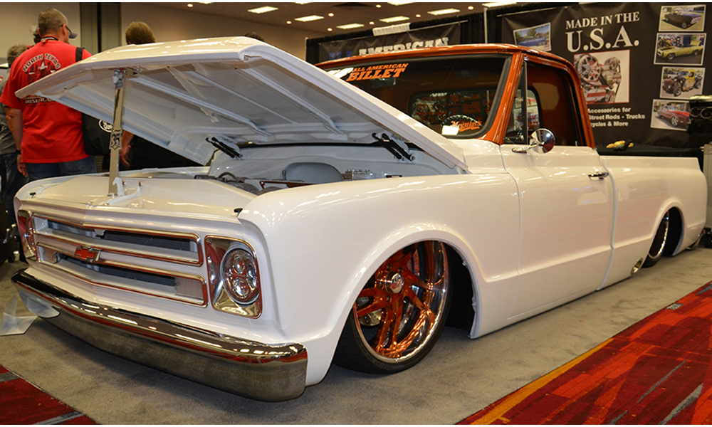 1967 Chevy C10 featuring Universal Pro Series bench in SPORT 2-Tone design with camel vinyl, brown hounds-tooth center, and white contrast stitching. Includes matching dash pad and door panels with new carpet kit.