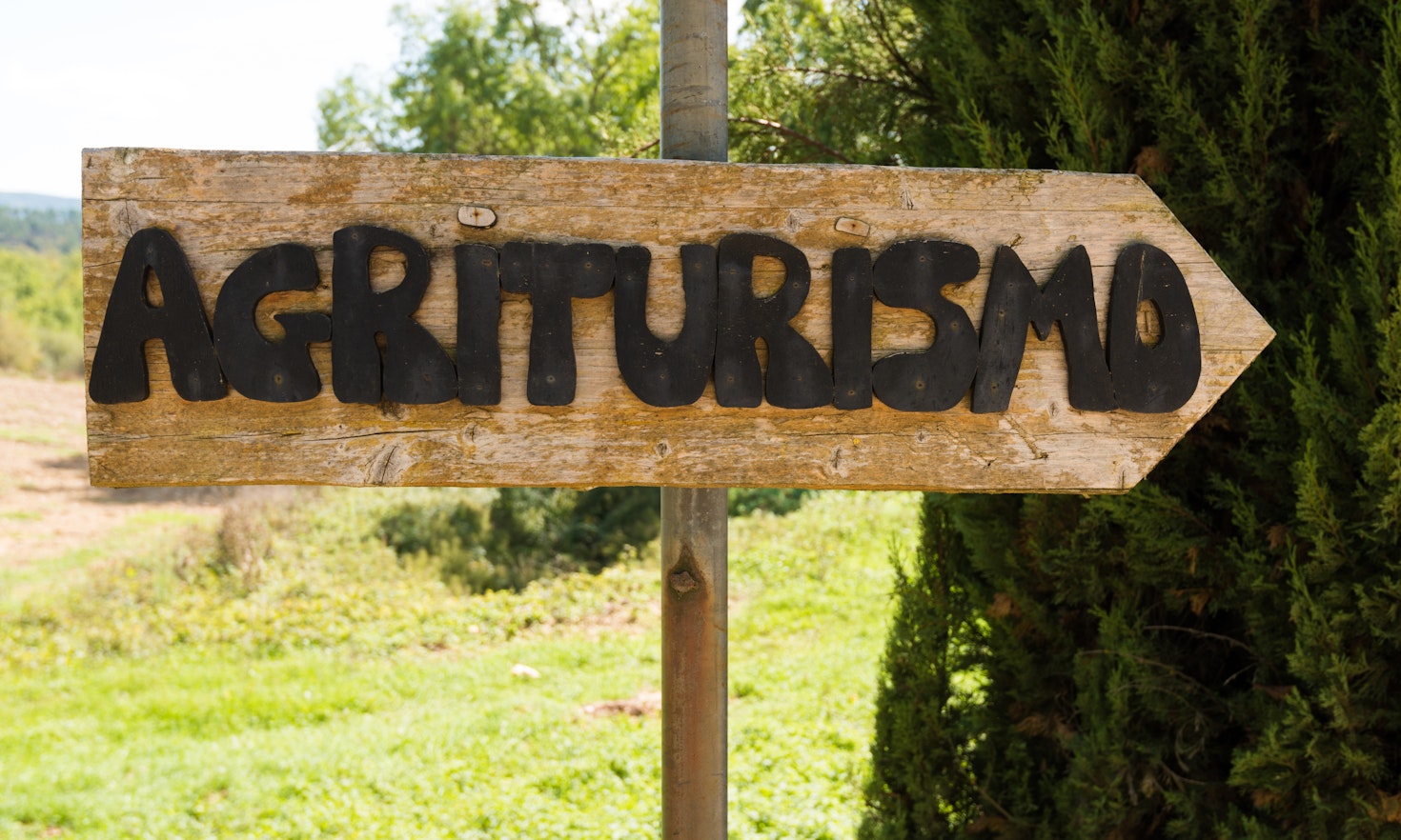 Handmade wooden agriturismo sign in Tuscany – agritourism is a typical concept of bed and breakfast in a farming environment in Italy.