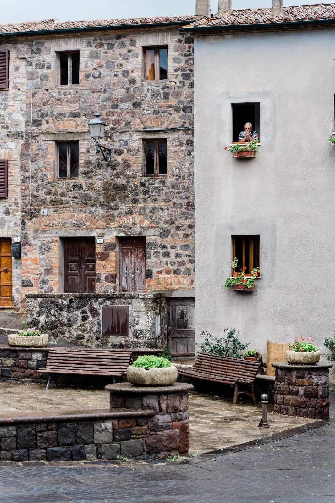 person looking out of old stone house window