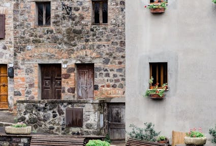 person looking out of old stone house window