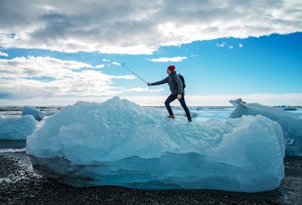 Tourist man taking selfie on small iceberg Located in Diamond beach near Jokulsarlon Lagoon, Iceland