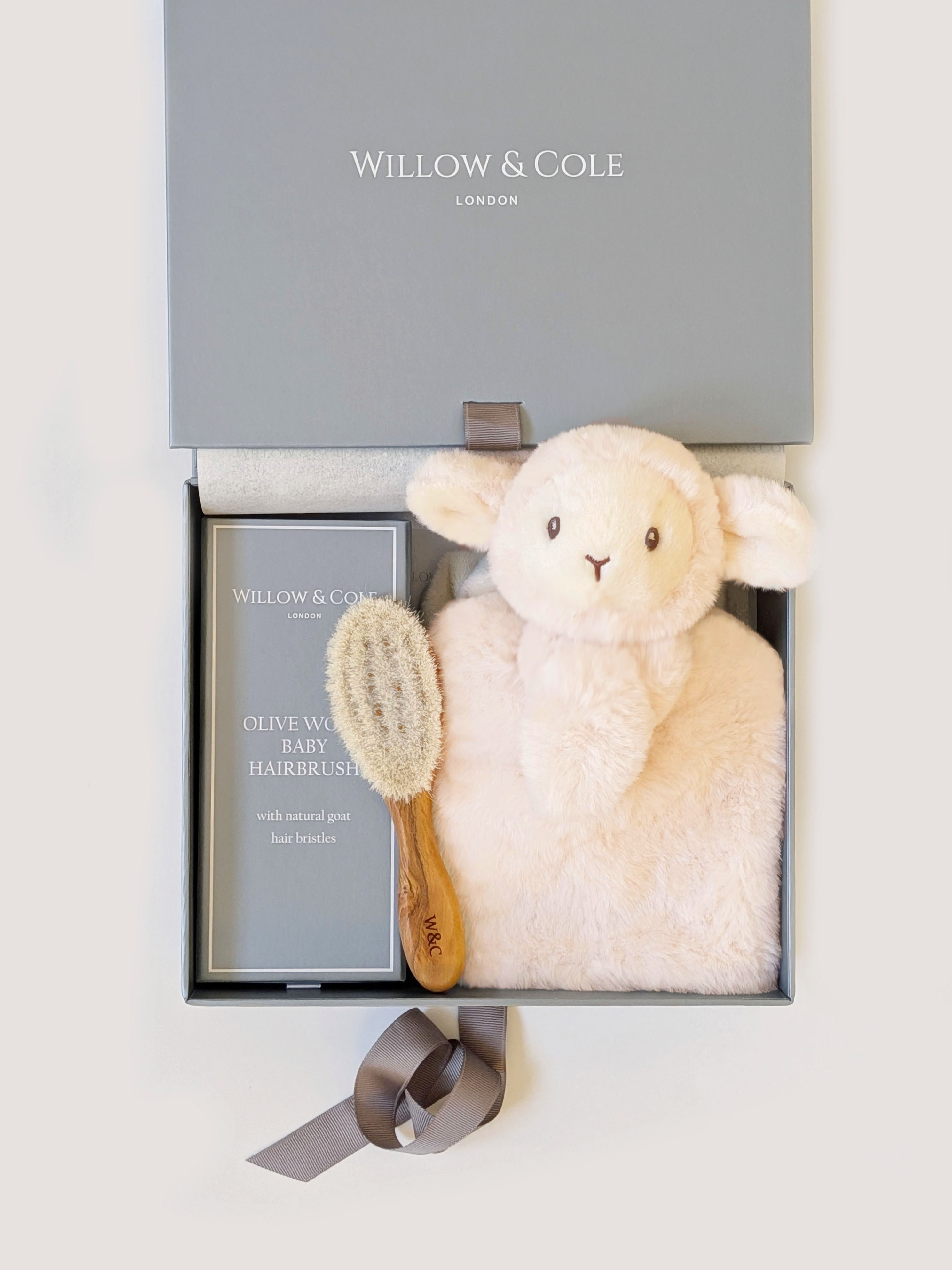 A luxury newborn gift set pairing our softest plush lamb with a natural olivewood baby brush. Presented in the Willow & Cole gift box.