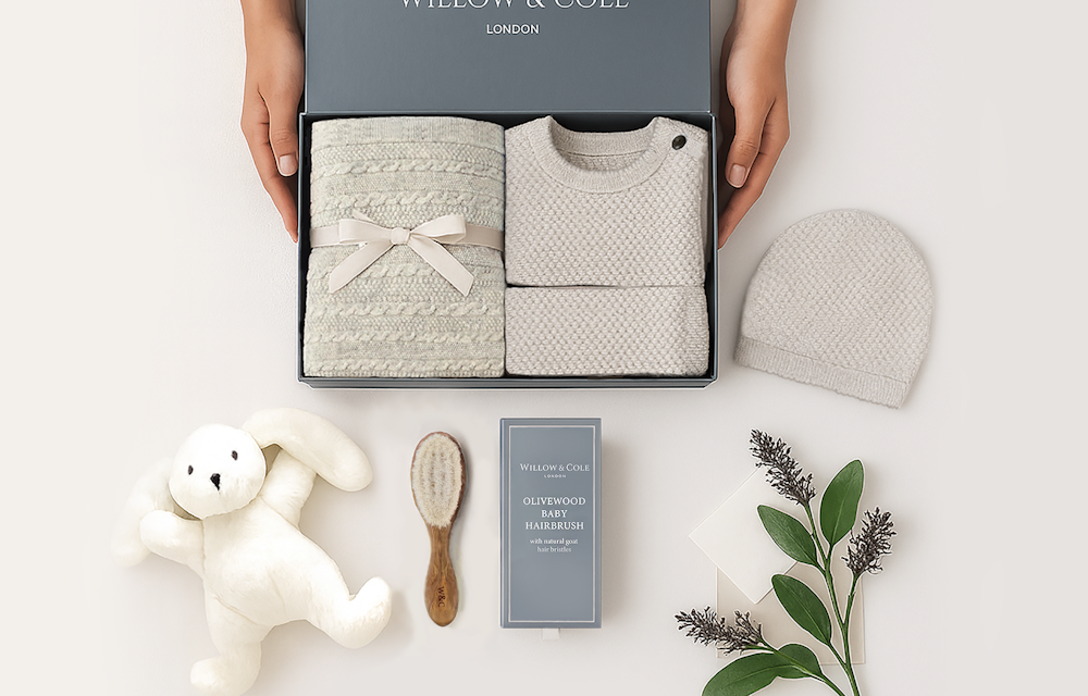 Luxury Willow & Cole newborn gift ideas including cashmere baby blankets, bonnet and booties sets, plush lamb toys and baby accessories presented in a gift box