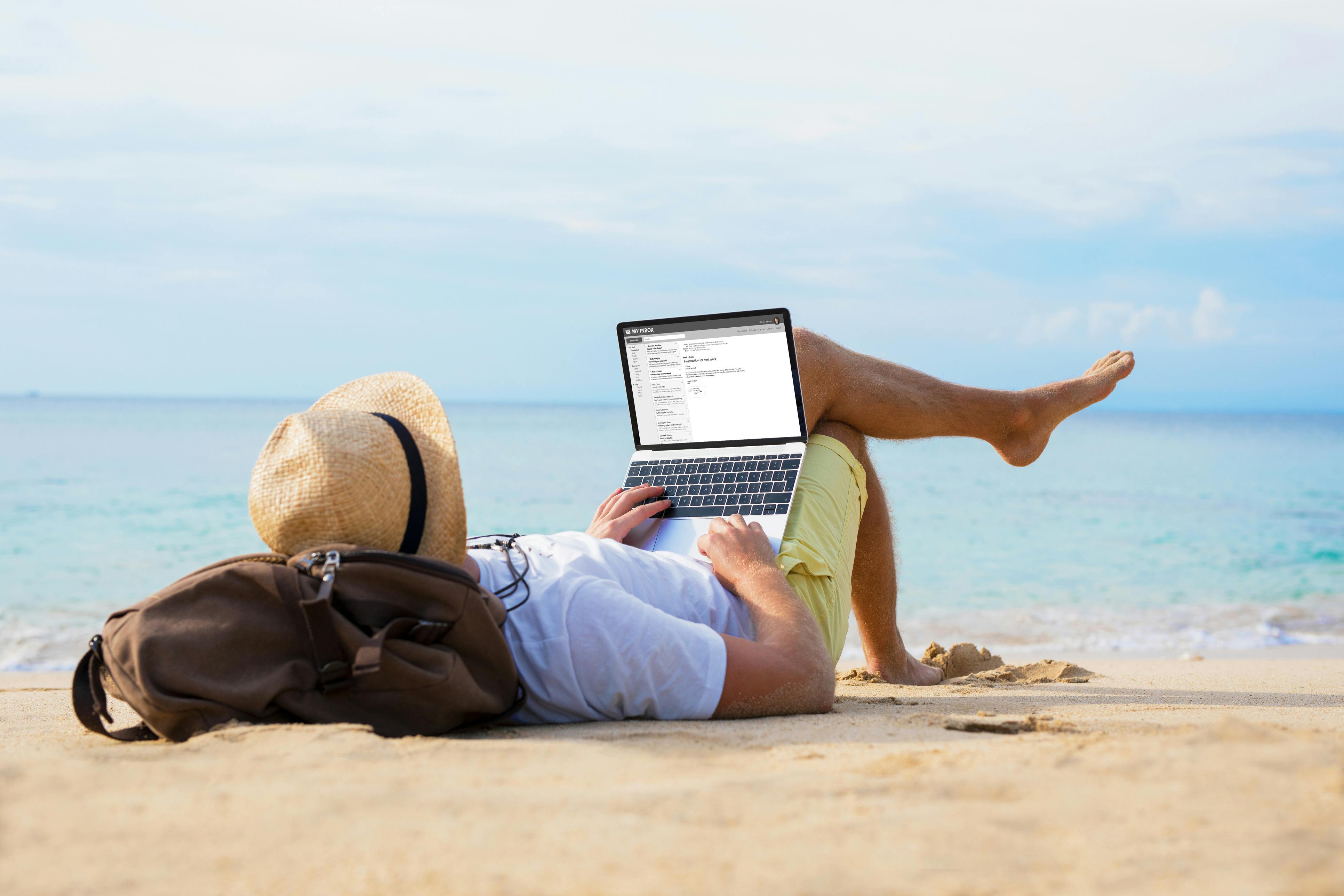 op het strand met MacBook