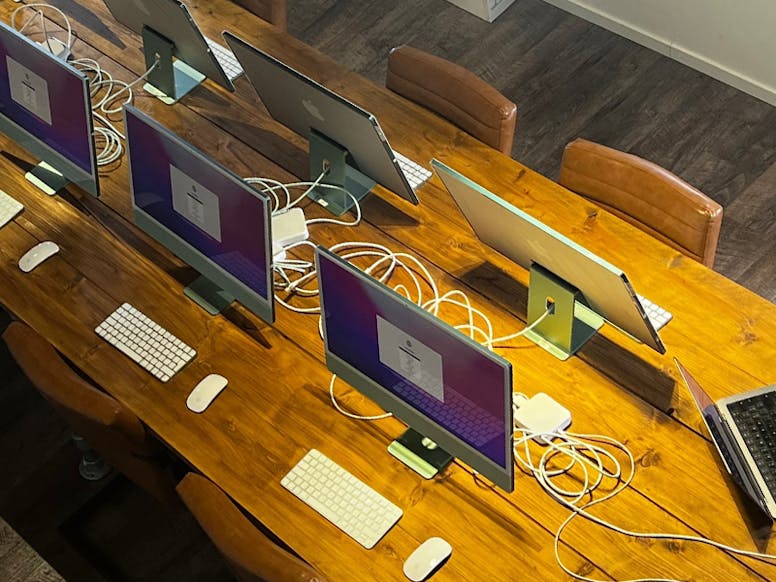 Tafel vol met Macs, klaar om geïnstalleerd te worden.