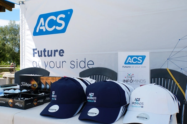 Il banchetto dell'accettazione alla IT Business Cup ACS & INFOMINDS, con cappellini e palline esposti.