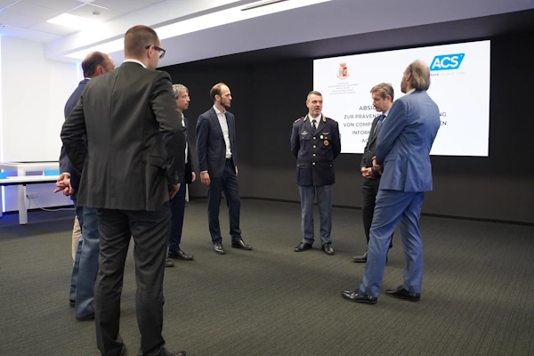 Rappresentanti di ACS Data Systems e della Polizia di Stata discutono dopo la firma dell'accordo.