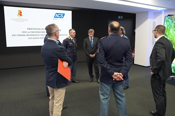 Rappresentanti di ACS Data Systems e della Polizia di Stata parlano in cerchio dopo la firma dell'accordo.