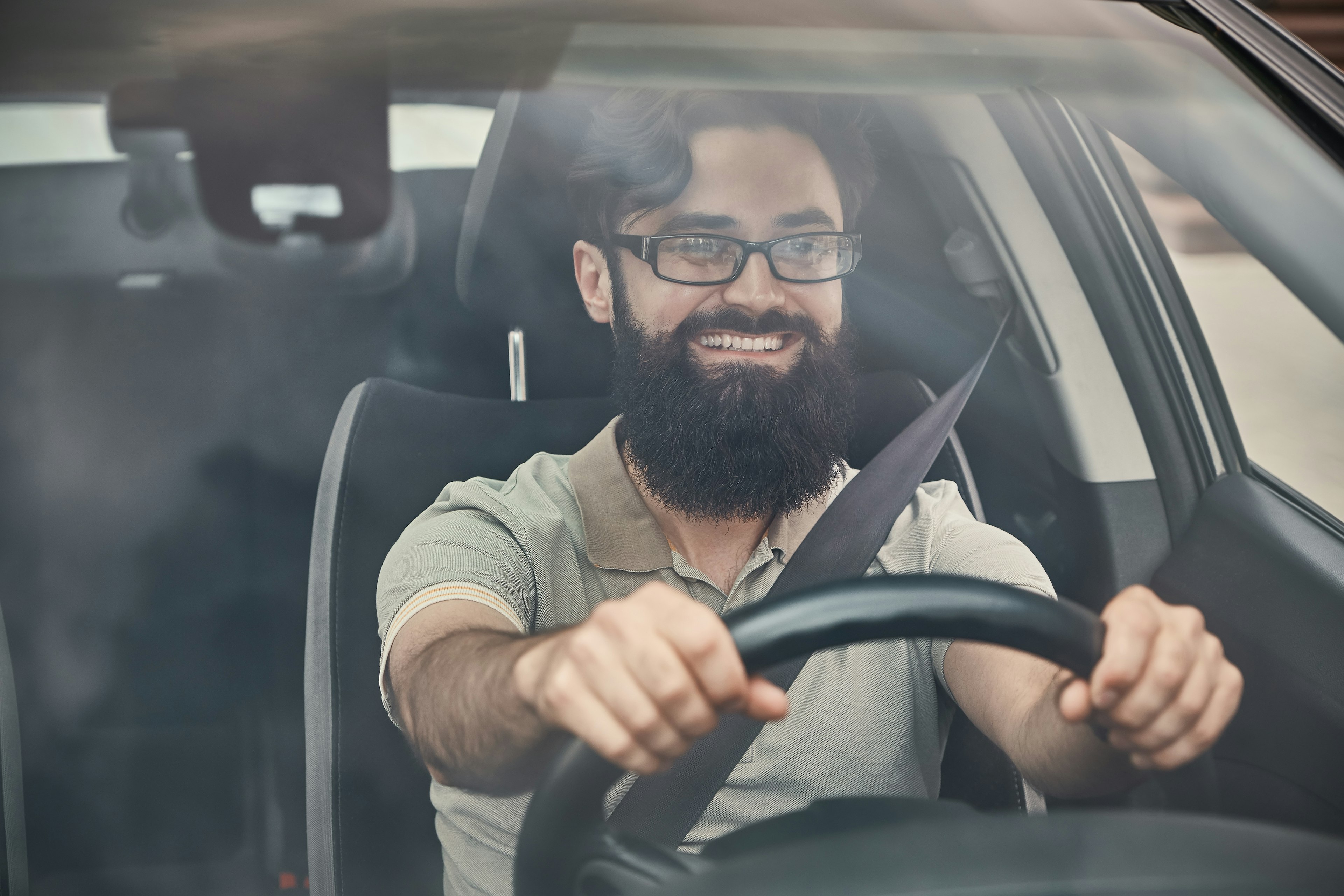 Man driving a car while smiling