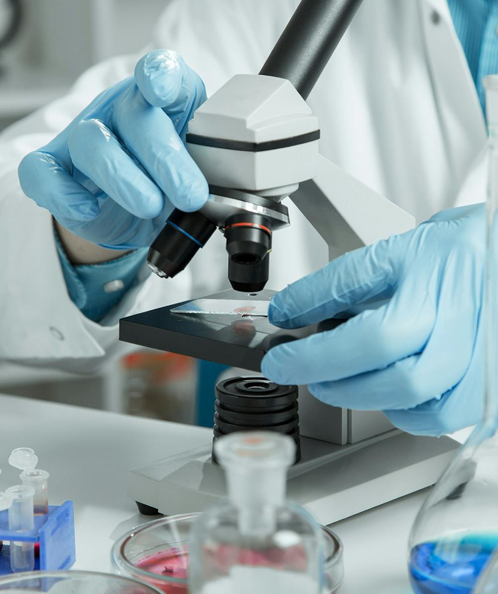 Doctor studying a liquid biopsy through microscope