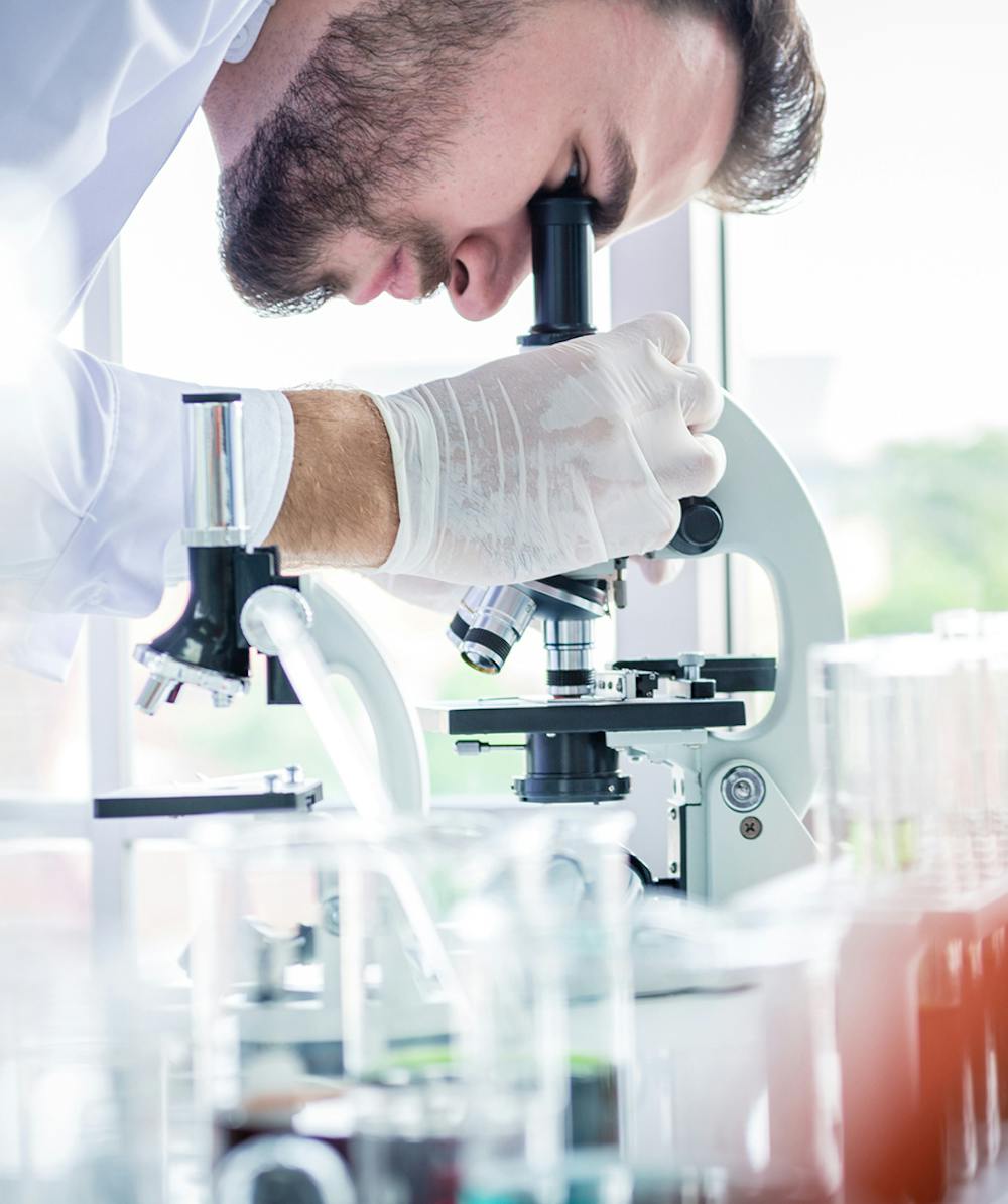 Doctor examing patient's molecular genetics through microscope