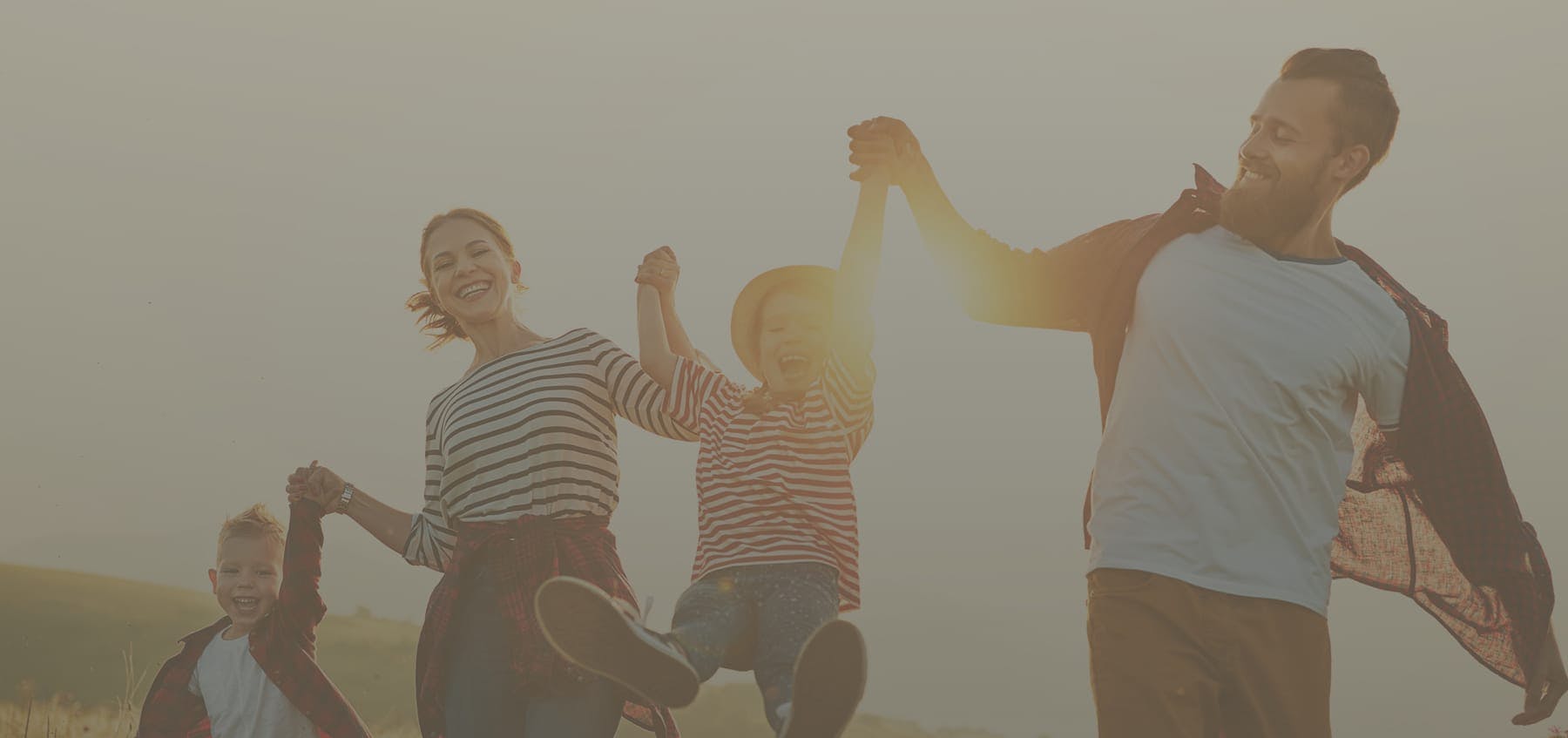 Family walking together with the sunset behind them. All smiling