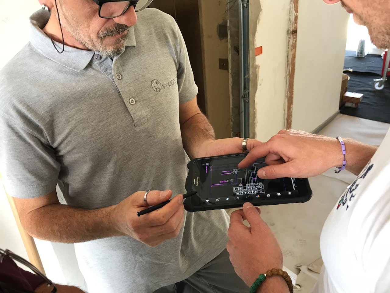 Operatore e cliente che visionano il progetto da tablet e firmano digitalmente 