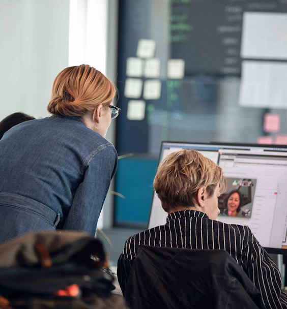 Two people at their desk participating in a virtual meeting.