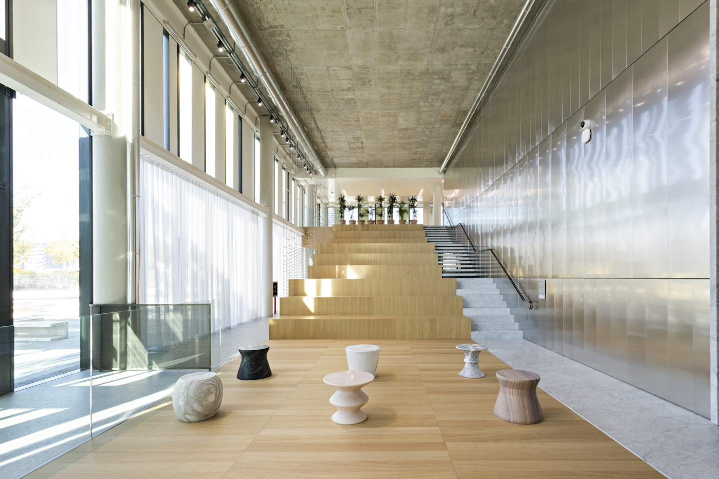 Entrance to the Milan studio with large stairways, plants and interior decorations