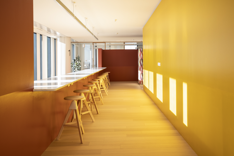 Studio close-up front view with a large table and some stools