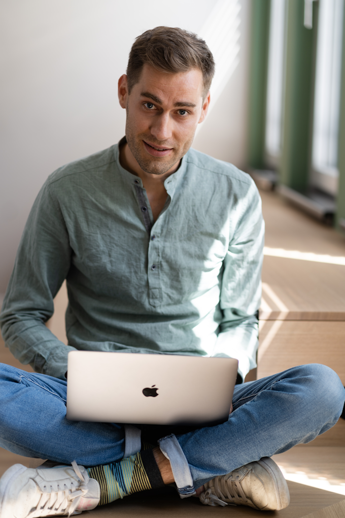 A designer sitting on the ground with their laptop