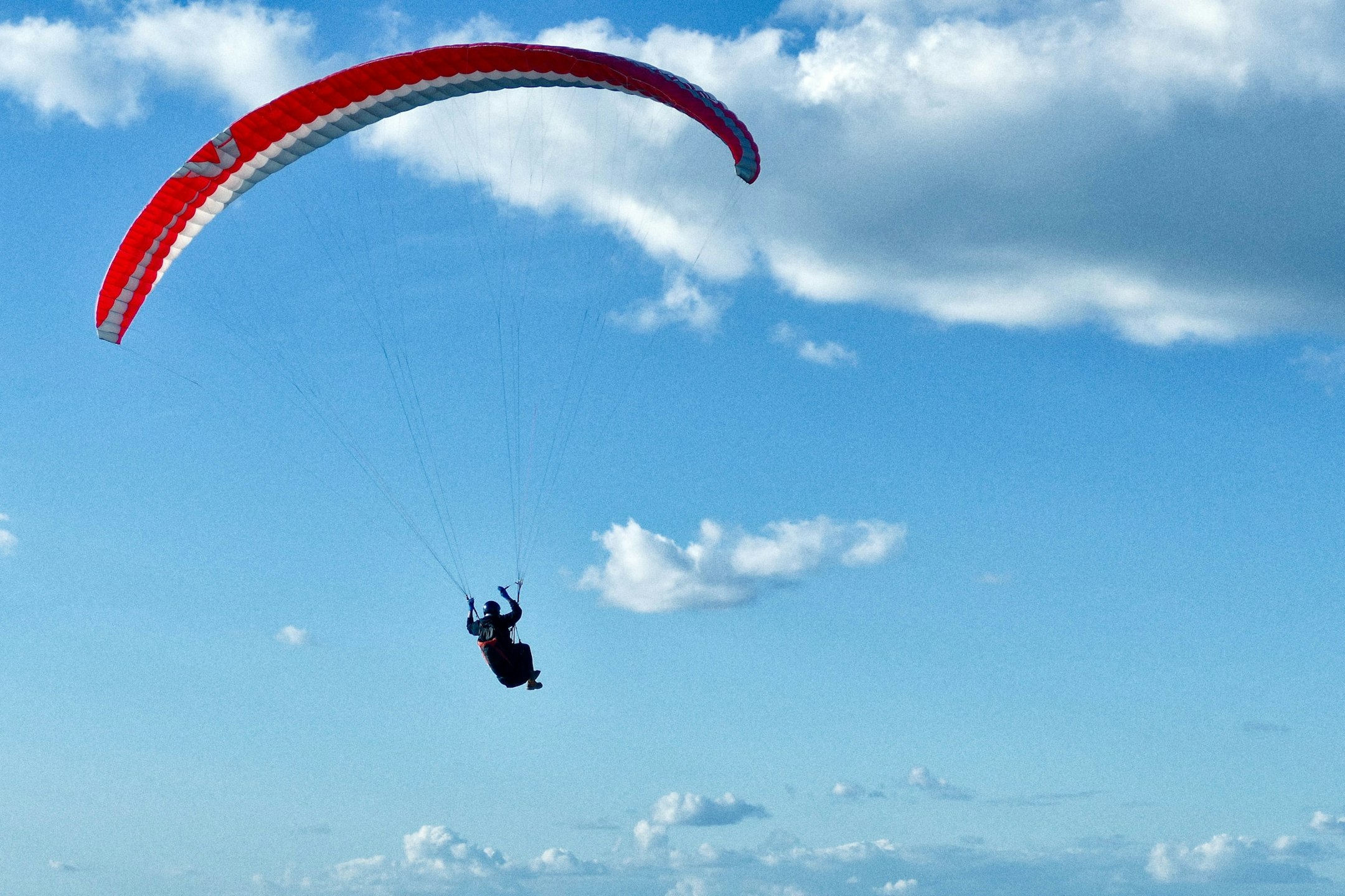 Person paragliding through the sky