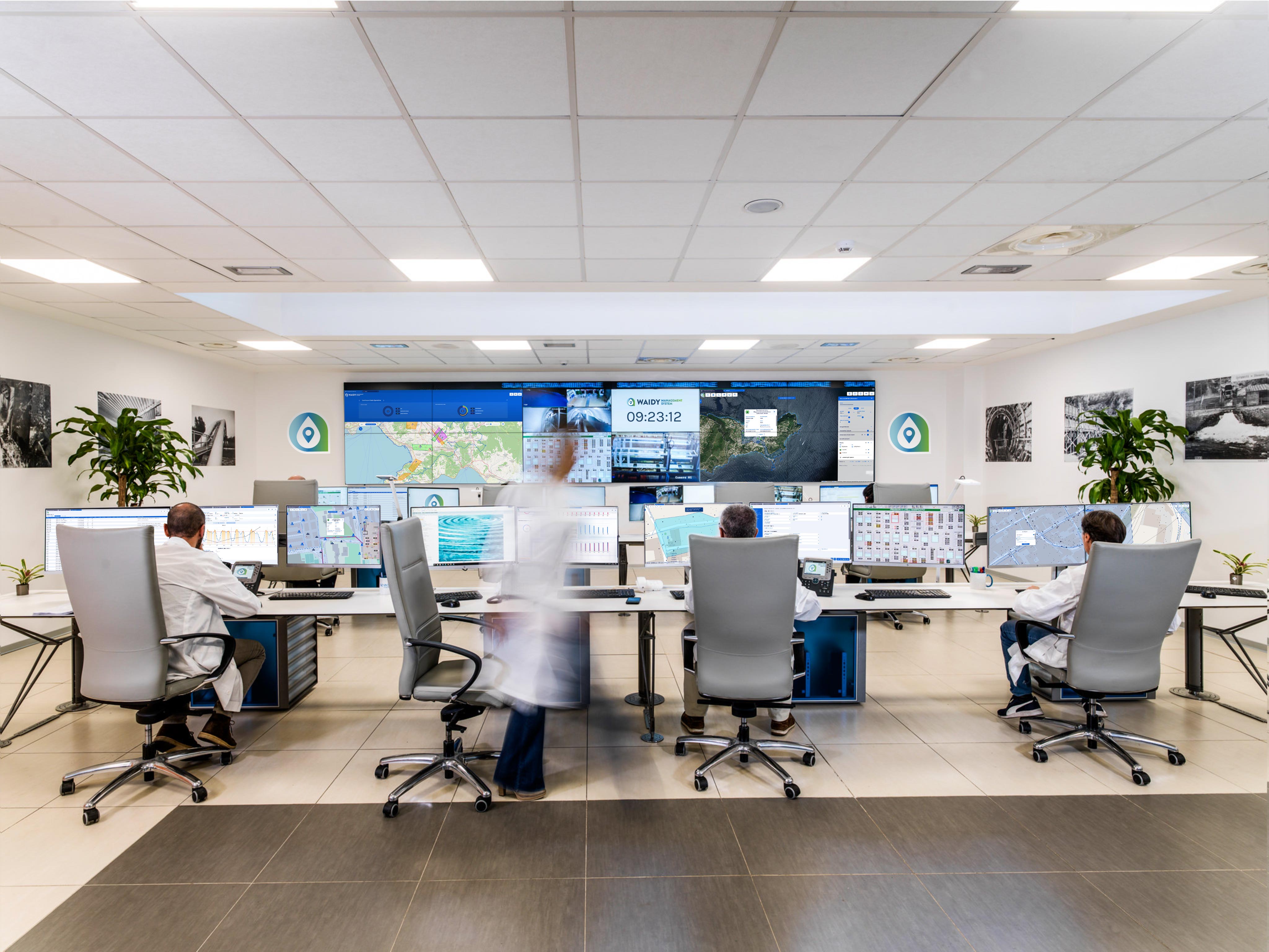 Employees sitting in front of monitors working with Waidy Water Mangement System