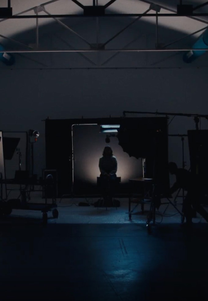 A person from the back being recorded in a studio with soft lights