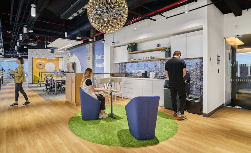 Three people sitting in kitchen of open space