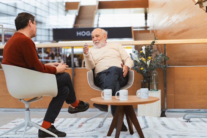 Two men having a conversation at the Club de Creatividad 2025.