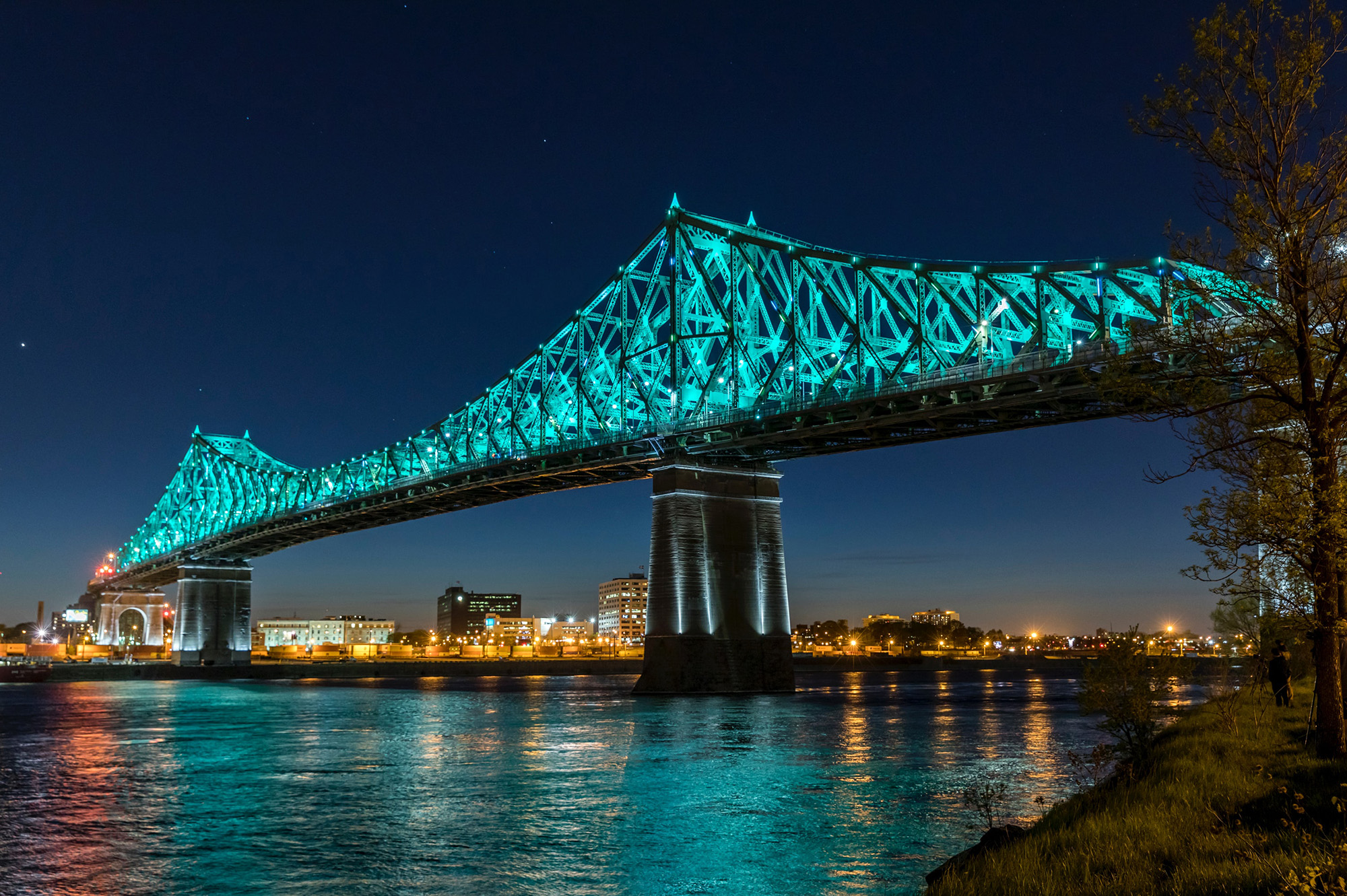 Large suspension bridge lit up blue against night sky