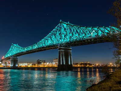 Large suspension bridge lit up blue against night sky