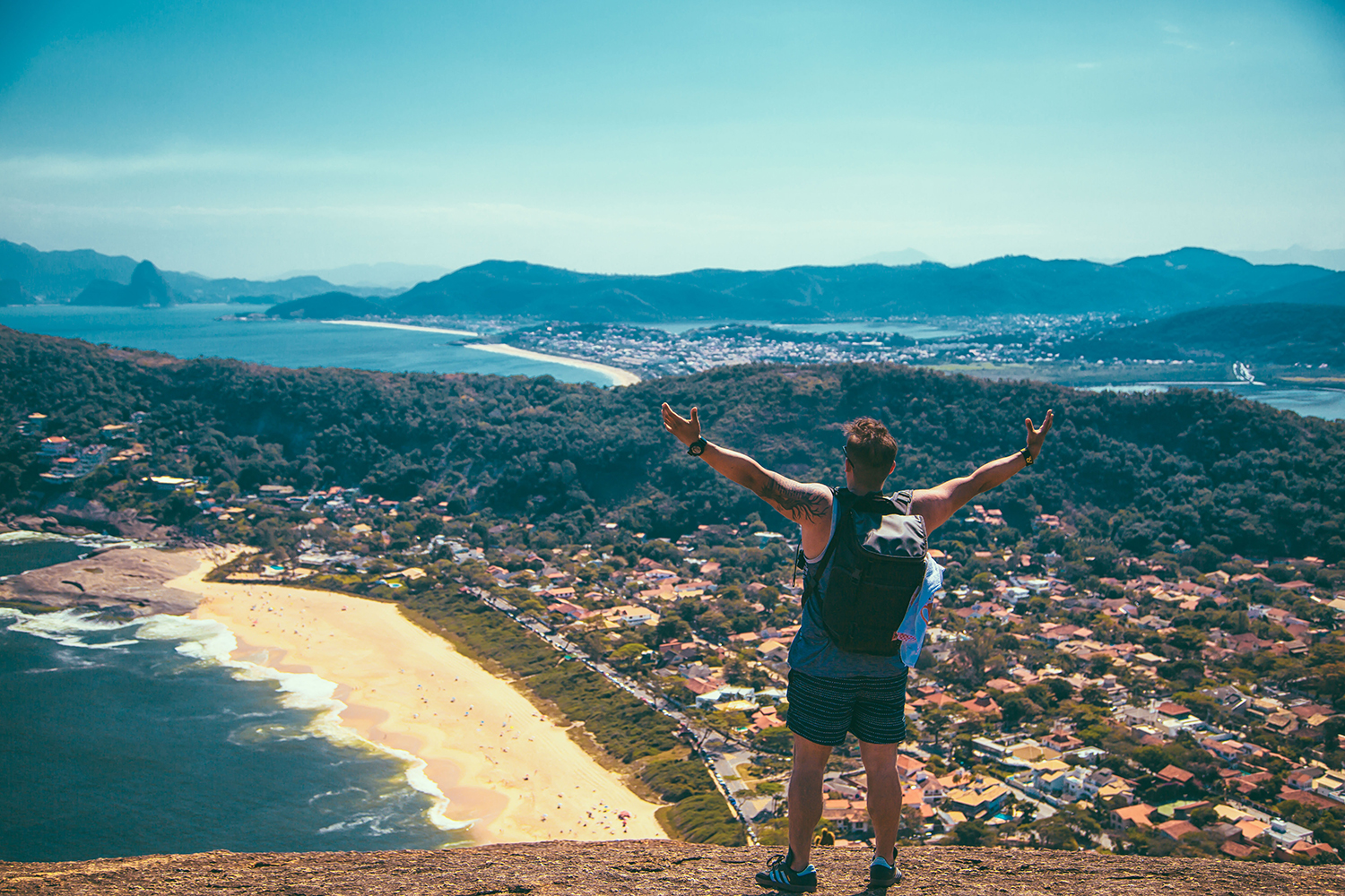 Man on cliff overlooking a city 