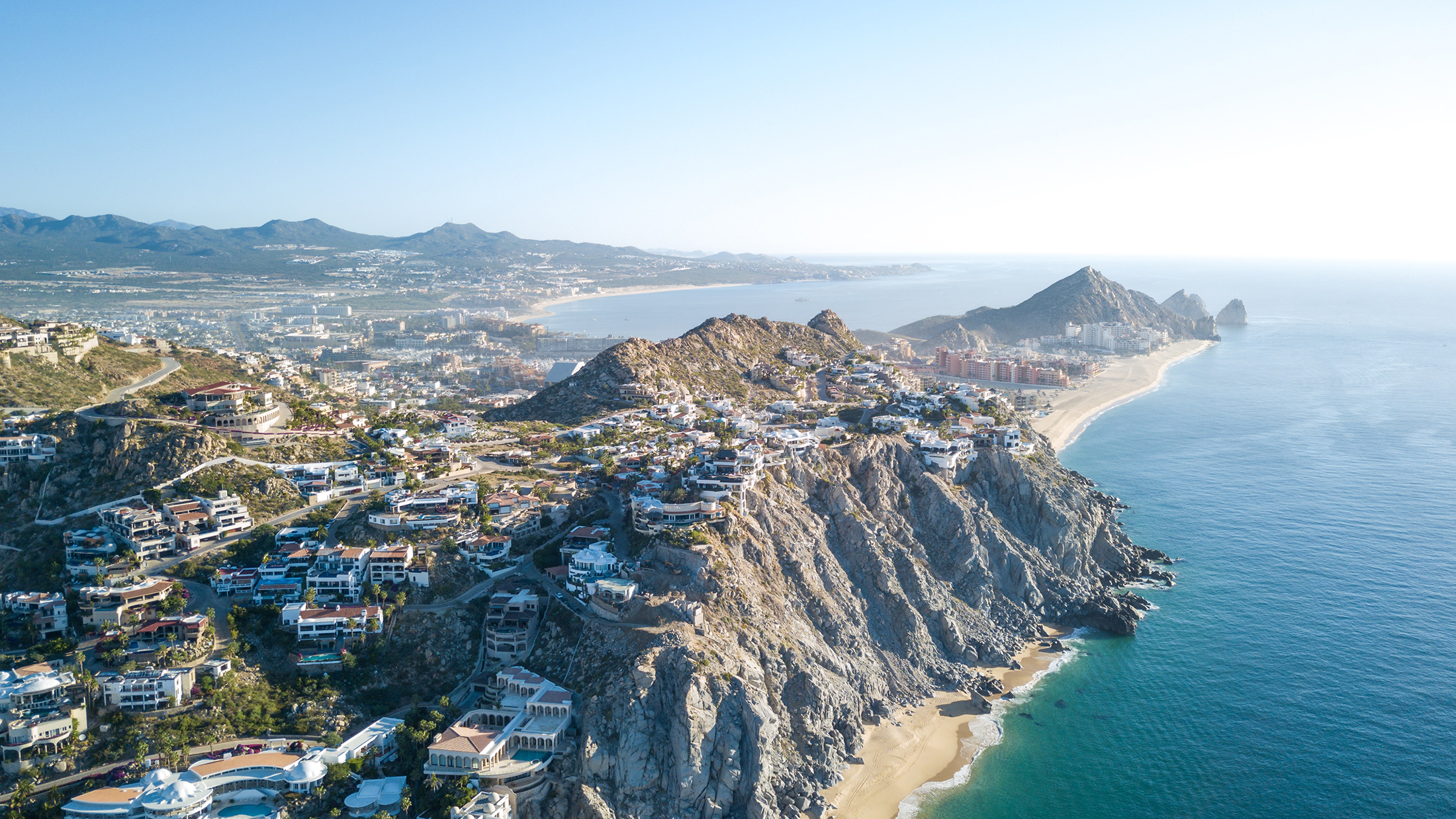 Luxury houses built into rocky hills on coast