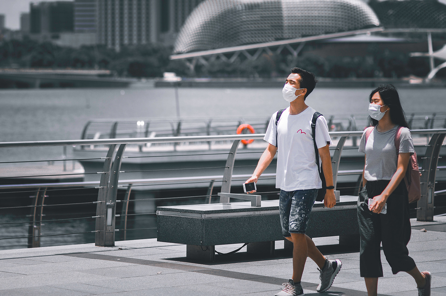 Two young people walking with masks