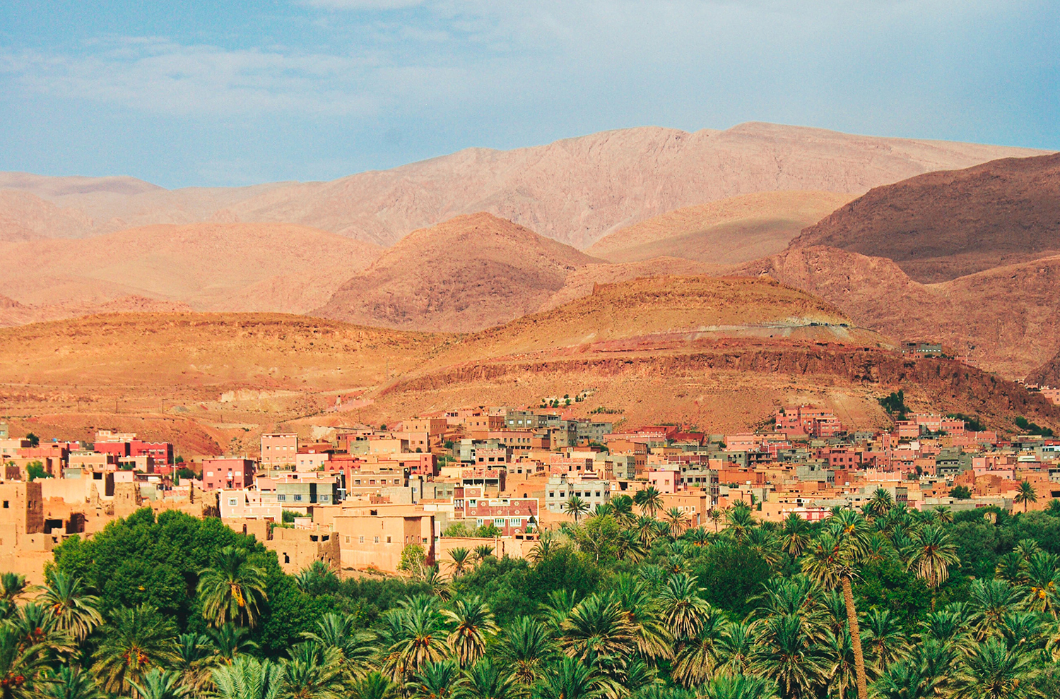 Distant view of city in Morocco between trees and desert hills