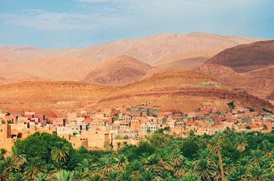 Distant view of city in Morocco between trees and desert hills