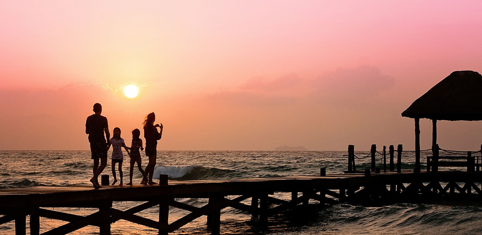 Family on a dock watching the sunset 