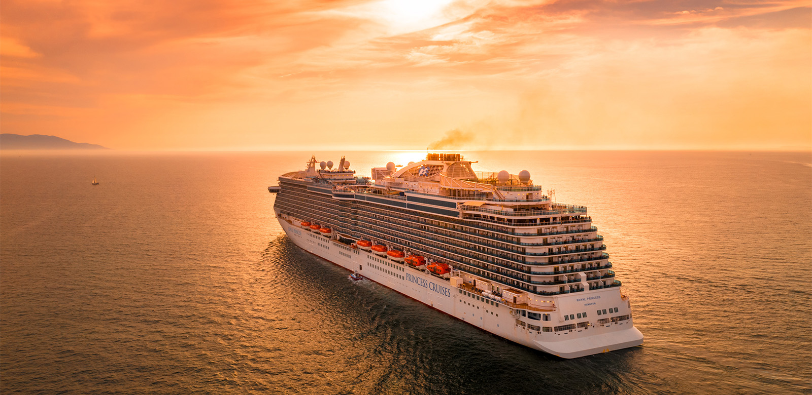 cruise ship facing horizon at sunset