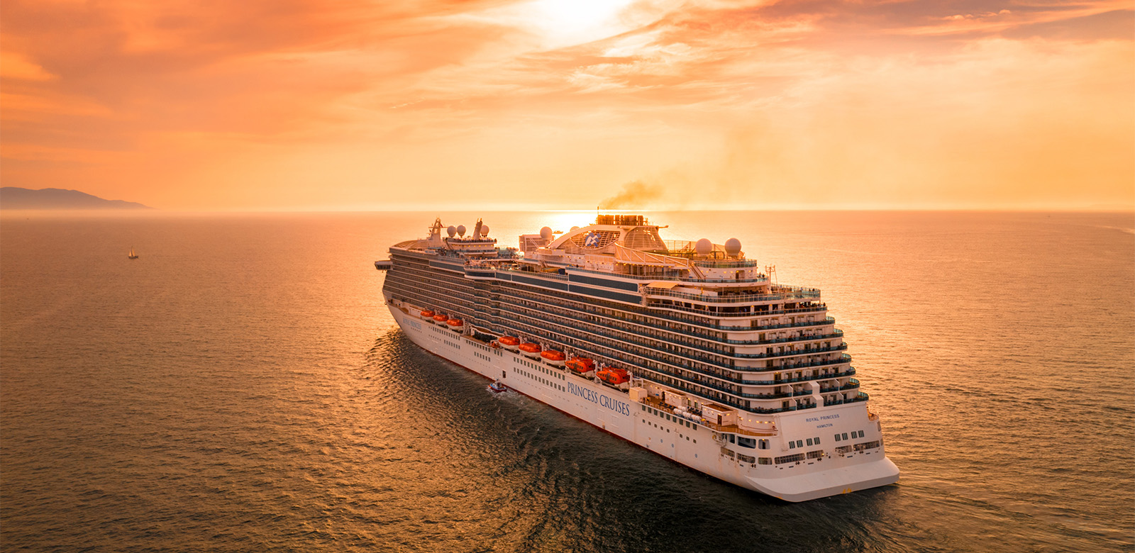 Cruise ship heading toward sunset horizon 