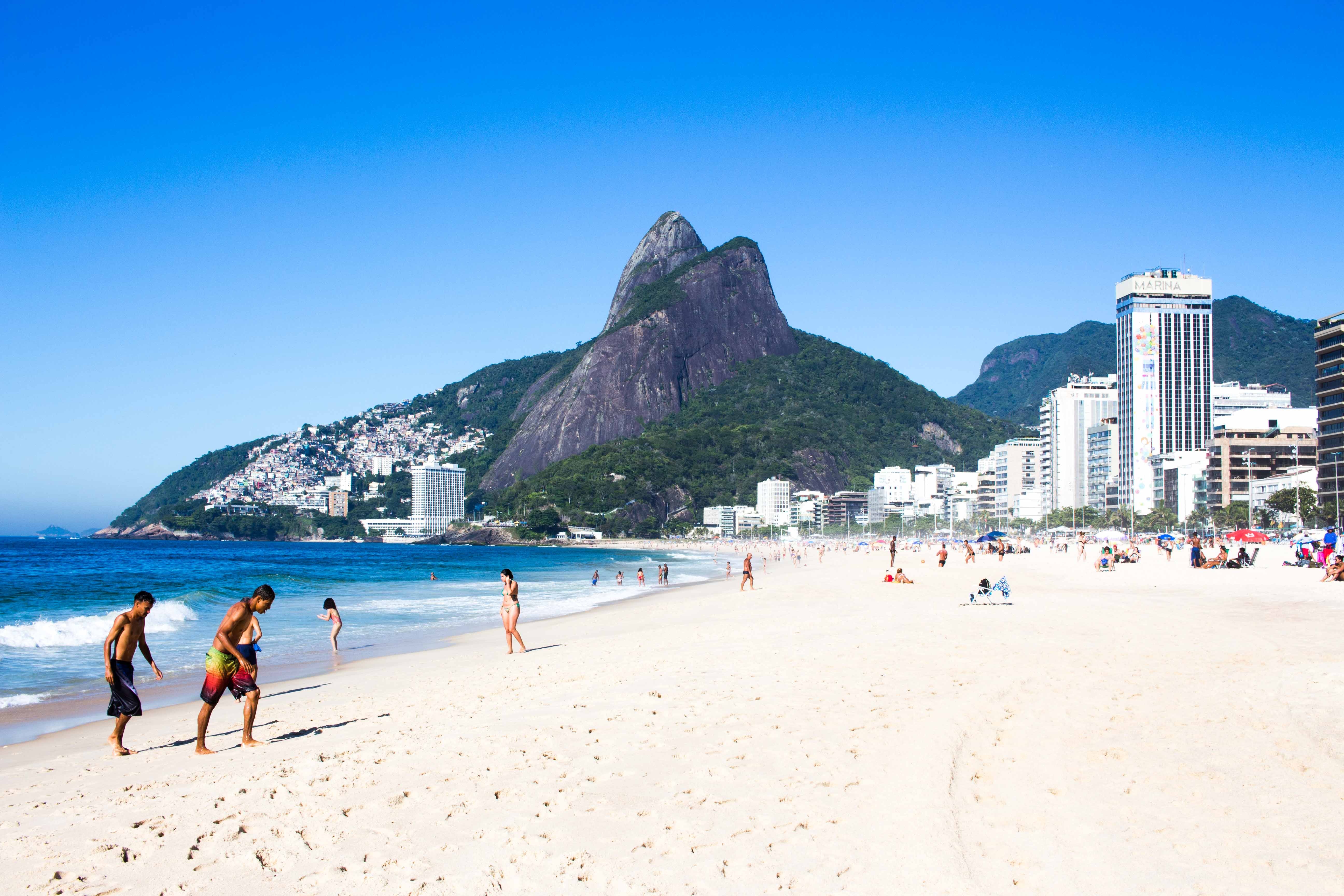 Sandy beach next to large city and mountains