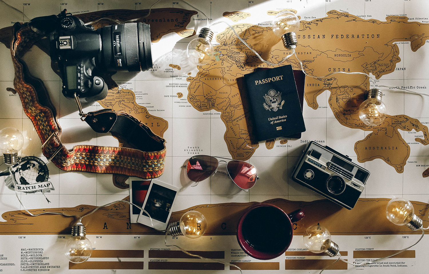 Cameras, glasses and passport sitting on map of world