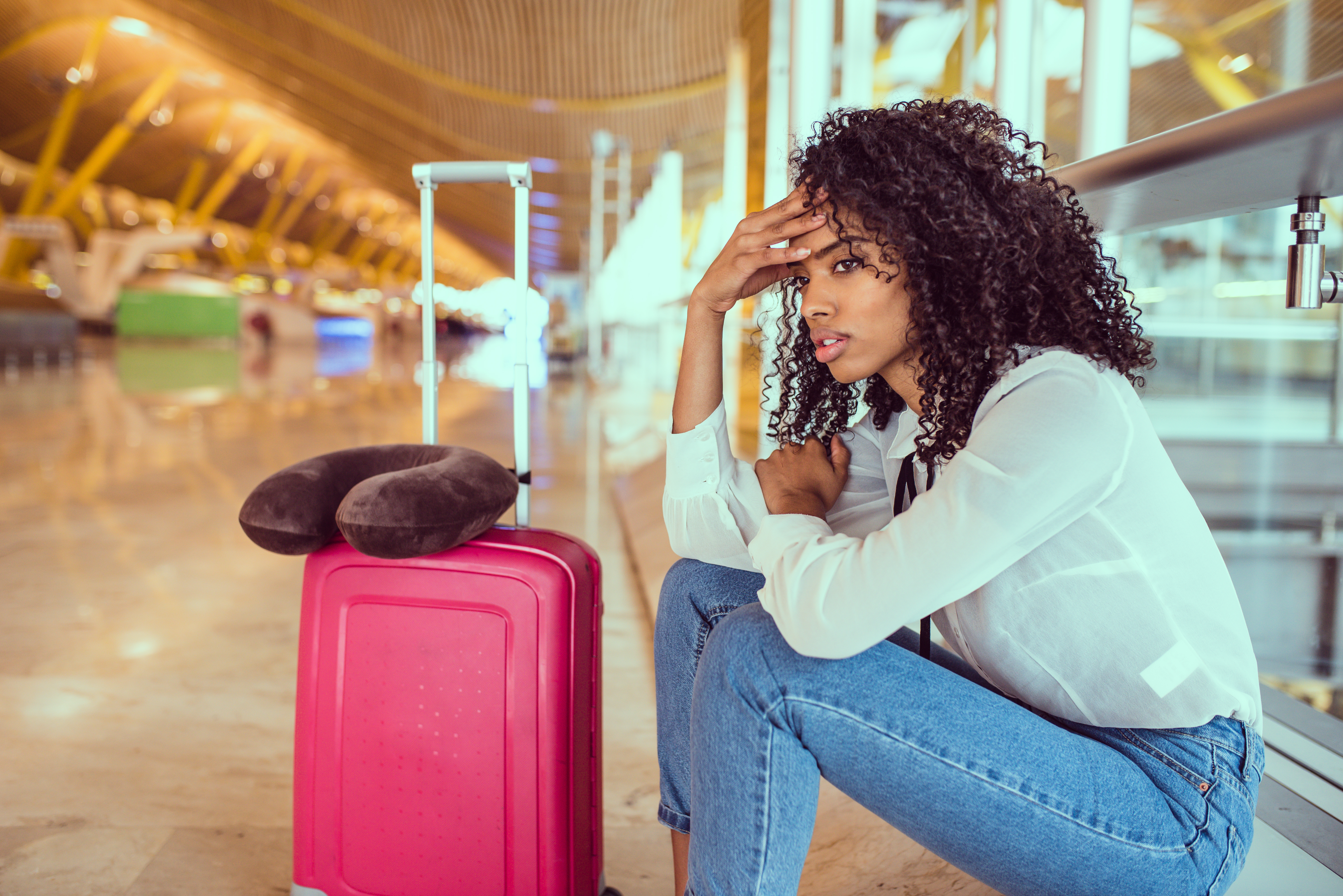 Woman sitting in airport looking frustrated