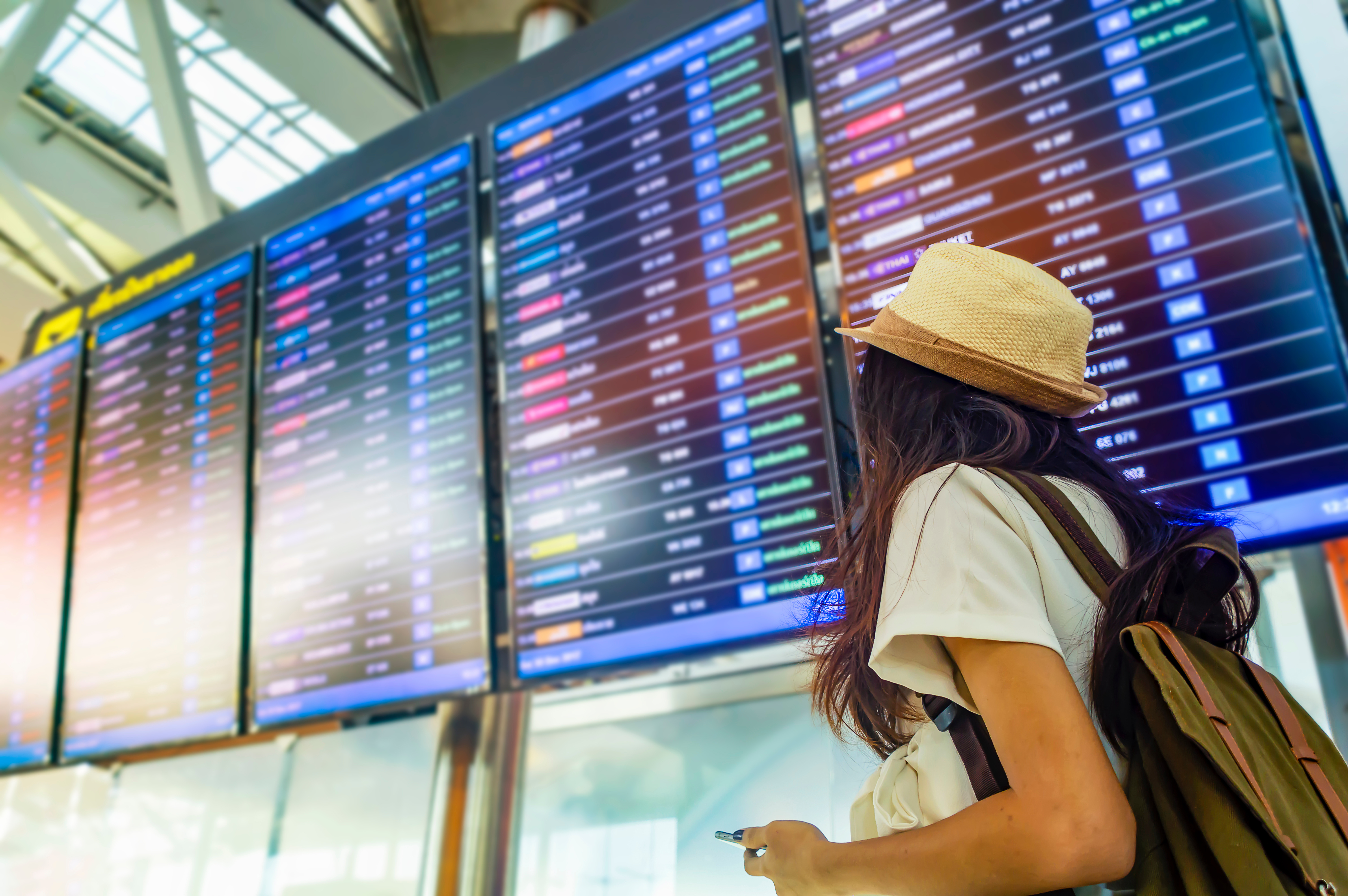 Woman looking at flight schedule board