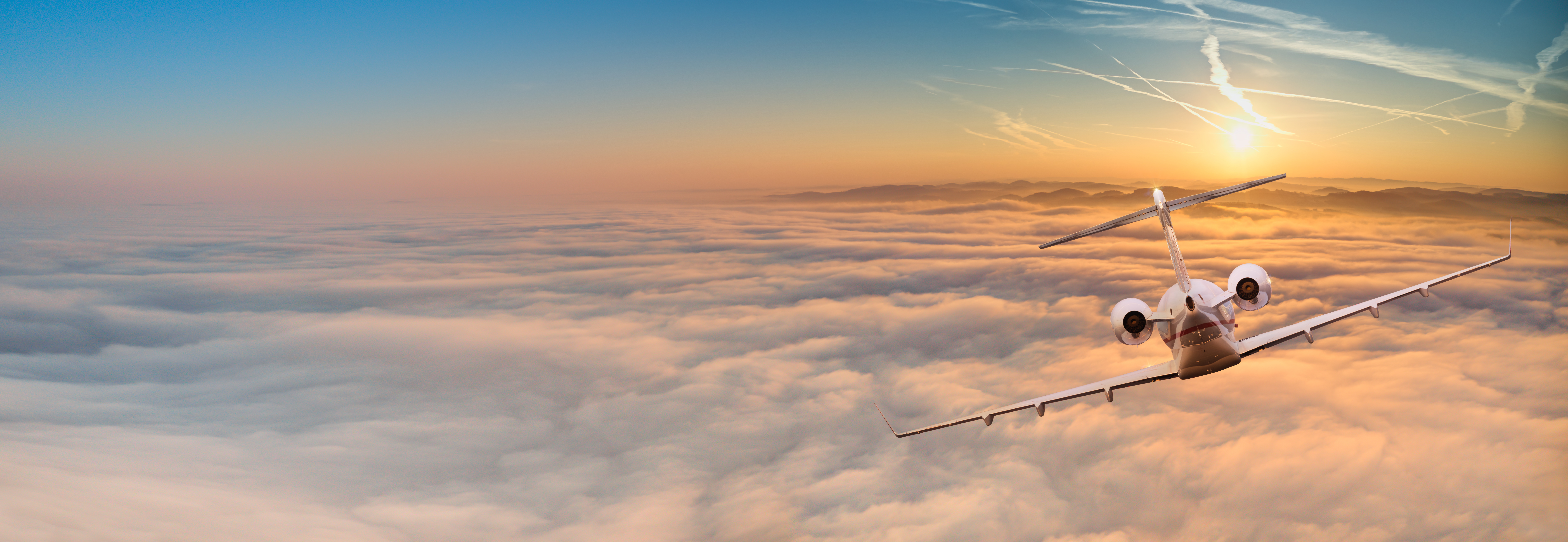 Private jet flying above clouds