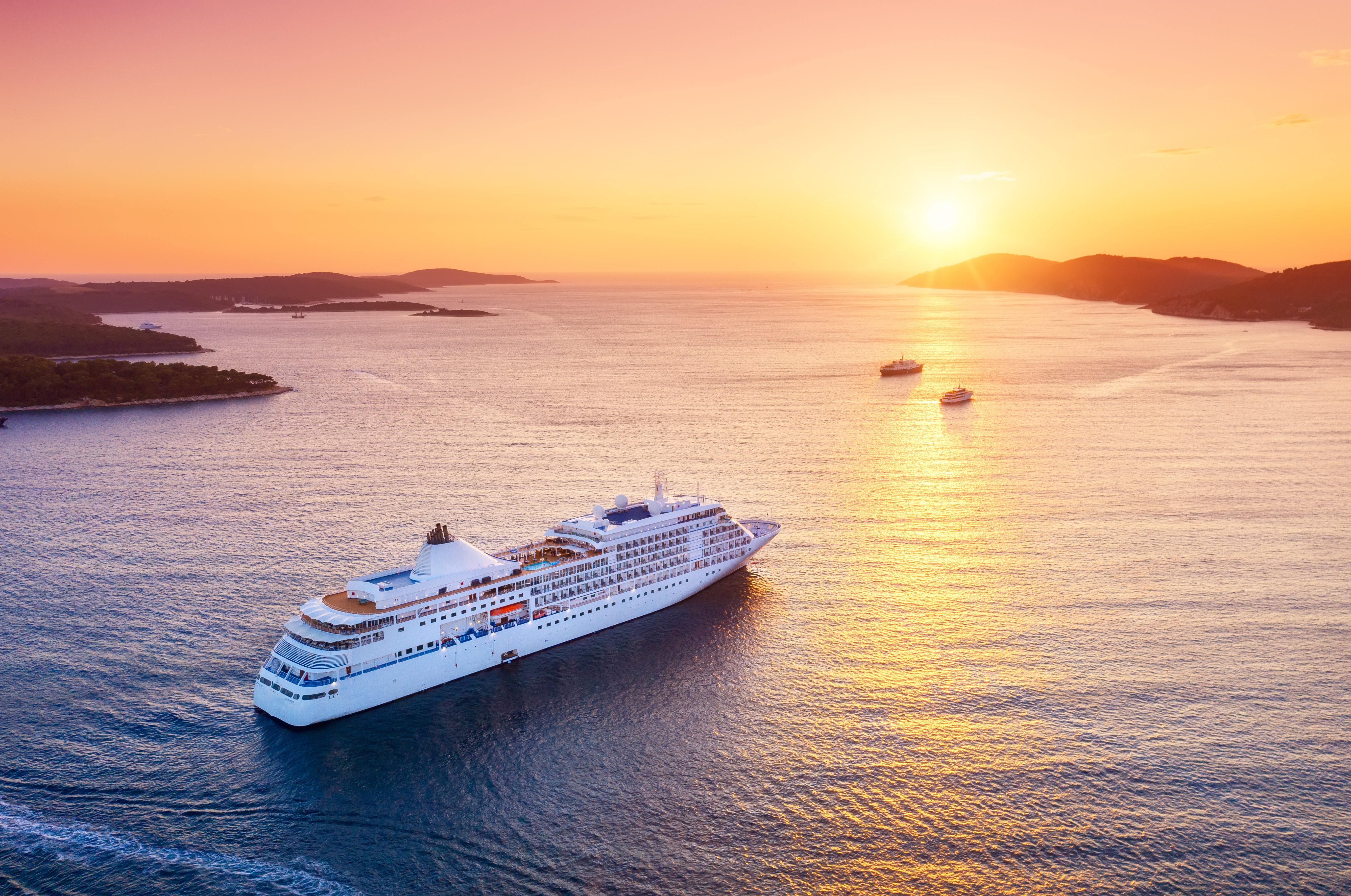 Cruise ship moving toward sunset