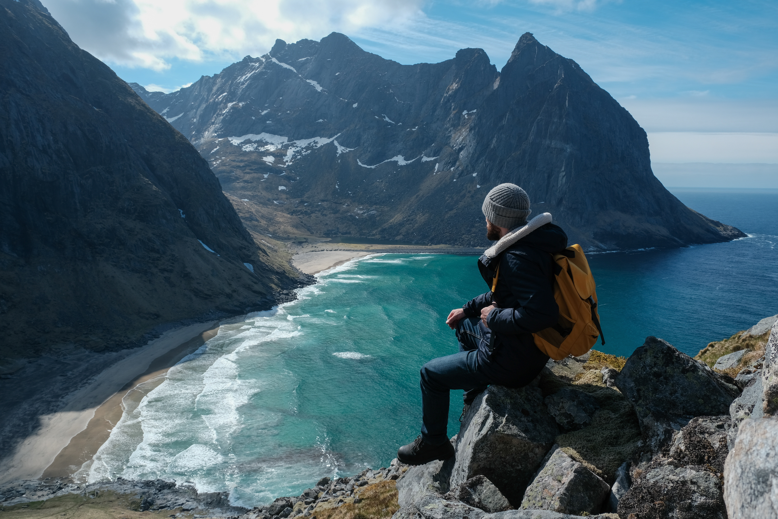 Man sitting on mountain looking at the sea